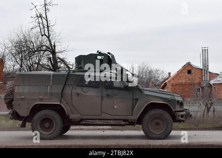 Orichhiv, Ukraine. Dezember 2023. Ein gepanzertes ukrainisches Militärfahrzeug, das auf der Straße entlang der privaten Häuser vorbeifährt, die durch russische Bombenangriffe in Orichschiw zerstört wurden. Der ukrainische Präsident Wolodymyr Zelenskyj sagte, er habe eine Erweiterung der Verteidigungsanlagen über das Schlachtfeld angeordnet. Nach dem Scheitern der ukrainischen Gegenoffensive von 2023 könnte Zelenskyj die Ankündigung signalisieren, dass Kiew beabsichtigt, 2024 eine defensive Haltung einzunehmen. Wenn man sich hineingräbt, könnte die Ukraine dabei helfen, künftige russische Offensiven abzuwehren, während Kiew mehr Truppen für die Ausbildung im Westen ersparen kann. (Kreditbild: © Andr Stockfoto