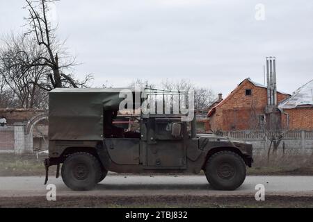 Orichhiv, Ukraine. Dezember 2023. Ein gepanzertes ukrainisches Militärfahrzeug, das auf der Straße entlang der privaten Häuser vorbeifährt, die durch russische Bombenangriffe in Orichschiw zerstört wurden. Der ukrainische Präsident Wolodymyr Zelenskyj sagte, er habe eine Erweiterung der Verteidigungsanlagen über das Schlachtfeld angeordnet. Nach dem Scheitern der ukrainischen Gegenoffensive von 2023 könnte Zelenskyj die Ankündigung signalisieren, dass Kiew beabsichtigt, 2024 eine defensive Haltung einzunehmen. Wenn man sich hineingräbt, könnte die Ukraine dabei helfen, künftige russische Offensiven abzuwehren, während Kiew mehr Truppen für die Ausbildung im Westen ersparen kann. (Kreditbild: © Andr Stockfoto