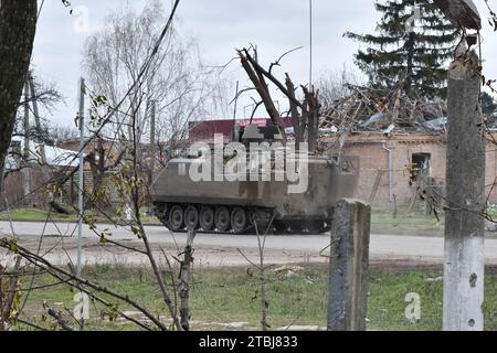 Orichhiv, Ukraine. Dezember 2023. Ein gepanzertes ukrainisches Militärfahrzeug, das auf der Straße entlang der privaten Häuser vorbeifährt, die durch russische Bombenangriffe in Orichschiw zerstört wurden. Der ukrainische Präsident Wolodymyr Zelenskyj sagte, er habe eine Erweiterung der Verteidigungsanlagen über das Schlachtfeld angeordnet. Nach dem Scheitern der ukrainischen Gegenoffensive von 2023 könnte Zelenskyj die Ankündigung signalisieren, dass Kiew beabsichtigt, 2024 eine defensive Haltung einzunehmen. Wenn man sich hineingräbt, könnte die Ukraine dabei helfen, künftige russische Offensiven abzuwehren, während Kiew mehr Truppen für die Ausbildung im Westen ersparen kann. (Kreditbild: © Andr Stockfoto