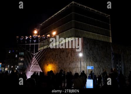 München, Deutschland. Dezember 2023. Zahlreiche Menschen stehen vor dem Hanukka-Leuchter vor der Hauptsynagoge Ohel Jakob am St. Jakobsplatz. Das achttägige jüdische Lichterfest Hanukkah beginnt am 7. Dezember 2023. Quelle: Sven Hoppe/dpa/Alamy Live News Stockfoto