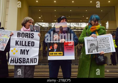 London, Großbritannien. Dezember 2023. Demonstranten und Hinterbliebene stehen vor dem COVID-19-Untersuchungszentrum, während der ehemalige Premierminister Boris Johnson am zweiten Tag aussagt. Quelle: Vuk Valcic/Alamy Live News Stockfoto