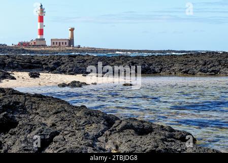 Natürliche Gezeitenbecken am Strand Playa de los Charcos und Leuchtturm von Toston - natürliche Pools am Strand von Los Laguitos oder Los Charcos auf Fuerteventura, Stockfoto