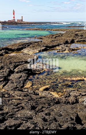 Natürliche Gezeitenbecken am Strand Playa de los Charcos und Leuchtturm von Toston - natürliche Pools am Strand von Los Laguitos oder Los Charcos auf Fuerteventura, Stockfoto