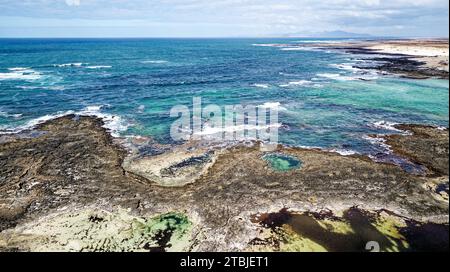 Blick aus der Vogelperspektive auf die natürlichen Gezeitenbecken des Playa de los Charcos Beach - natürliche Pools von Los Laguitos Beach oder Los Charcos auf Fuerteventura, Kanarische inseln Stockfoto