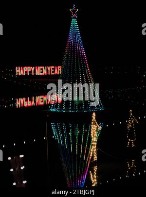Happy New Year Lichter und Weihnachtsbaum mit Lichtern und ihren Reflexen im Wasser Stockfoto
