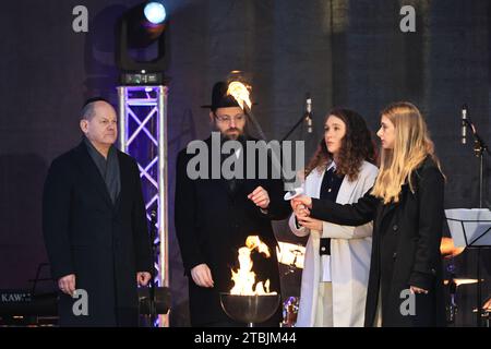 12.07.2023, Berlin, Deutschland. Kanzler Scholz und Rabbiner Yehuda Teichtal und die Familie des entführten deutsch-israelischen Yarden Roman auf der Bühne. Das achttägige jüdische Lichterfest Hanukka beginnt am Donnerstag, den 7. Dezember 2023. Die Zündung des ersten Lichtes findet als feierliche Zeremonie in Anwesenheit von Bundeskanzler Olaf Scholz, dem Regierenden Bürgermeister von Berlin Kai Wegner und S.E. dem israelischen Botschafter Prof. Ron Prosor statt. Stockfoto