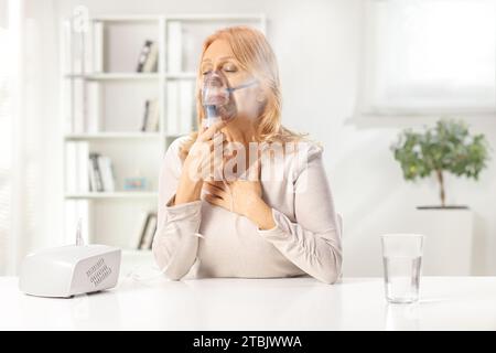 Frau, die zu Hause einen Vernebler mit Dampfnebel benutzt Stockfoto