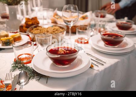 Weihnachtssuppe Rote Bete, Borschtsch mit kleinen Knödeln mit Pilzfüllung in einer Keramikschale auf einem Tisch. Traditionelles Weihnachtsgericht in Polen. Stockfoto