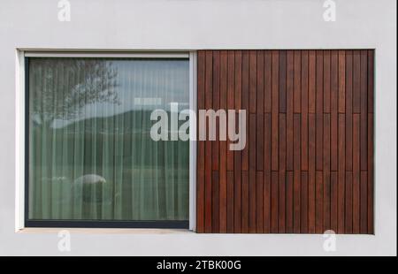 Holzfassadenverkleidung in Teakholz und große Glasfenster, moderne Architektur, Wandbauelemente Stockfoto