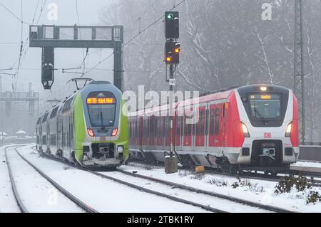 Hamburg, Deutschland. Dezember 2023. Vom Kieler Hauptbahnhof fährt ein Regionalexpress RE70 (l) des Nahverkehrsverbunds Schleswig-Holstein GmbH (nah.SH) in Richtung Bahnhof Dammtor. Auf der rechten Seite befindet sich eine S-Bahn der Linie S21 nach Aumühle. Quelle: Soeren Stache/dpa/Alamy Live News Stockfoto