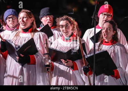 London, Großbritannien. Dezember 2023. Der Chor aus St. Martin-in-the-Fields. Die jährliche Zeremonie zum Einschalten des Weihnachtsbaums am Trafalgar Square sorgt für eine festliche Atmosphäre im Zentrum Londons, darunter Weihnachtslieder und Chorgesang. Jeden Dezember schickte ein Baum von Norwegen nach London als Geschenk, um Großbritannien für seine Unterstützung während des Zweiten Weltkriegs zu danken. In Anwesenheit von Patricia McAllister, der Bürgermeisterin von Westminster, der Bürgermeisterin von Oslo Anne Lindboe, der Bürgermeisterin von London Sadiq Khan, der norwegischen Sängerin Metteson und anderen. Quelle: Imageplotter/Alamy Live News Stockfoto