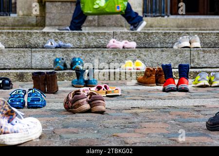 "Wir haben diese Schuhe vor der Kathedrale von Truro aufgegeben, wie unsere Abgeordneten Kinder verlassen haben" - die Schuhe repräsentieren die Trennung von Flüchtlingsfamilien. Stockfoto