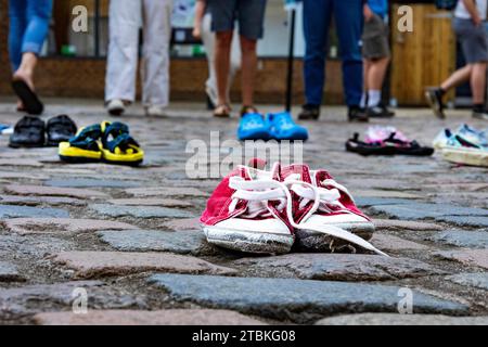 "Wir haben diese Schuhe vor der Kathedrale von Truro aufgegeben, wie unsere Abgeordneten Kinder verlassen haben" - die Schuhe repräsentieren die Trennung von Flüchtlingsfamilien. Stockfoto