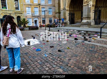 "Wir haben diese Schuhe vor der Kathedrale von Truro aufgegeben, wie unsere Abgeordneten Kinder verlassen haben" - die Schuhe repräsentieren die Trennung von Flüchtlingsfamilien. Stockfoto