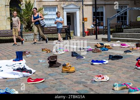 "Wir haben diese Schuhe vor der Kathedrale von Truro aufgegeben, wie unsere Abgeordneten Kinder verlassen haben" - die Schuhe repräsentieren die Trennung von Flüchtlingsfamilien. Stockfoto