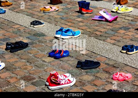 "Wir haben diese Schuhe vor der Kathedrale von Truro aufgegeben, wie unsere Abgeordneten Kinder verlassen haben" - die Schuhe repräsentieren die Trennung von Flüchtlingsfamilien. Stockfoto