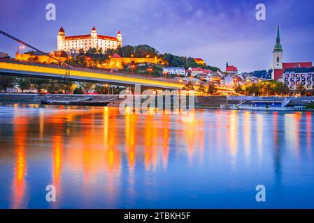 Bratislava, Slowakei. Schloss Bratislava und Altstadt über der Donau, Sonnenuntergang in der Dämmerung. Stockfoto