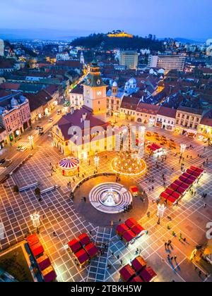 Brasov, Rumänien. Blick auf die Drohne aus der Luft mit Weihnachtsmarkt auf dem Hauptplatz in der Dämmerung schöne Lichter, Transsilvanien Urlaubsziel. Stockfoto