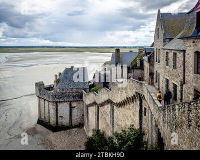 Normandie, Frankreich, 22. September 2023, Blick auf einige Menschen, die auf einer der Vorhangfassaden des Mont Saint-Michel laufen Stockfoto