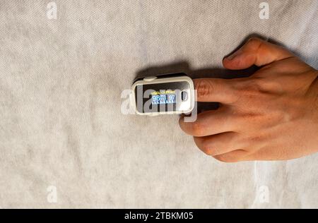 Hand mit einem Oximeter auf weißem Hintergrund Stockfoto