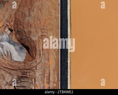 Drohnenbilder einer Baustelle mit Ausrüstung, Schmutz, Rückhalteteich, Wasser und Betonrohren. Stockfoto