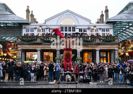 London, Großbritannien. Ein Straßenkünstler von Covent Garden unterhält die Menge. Die Künstler sind Teil einer jahrhundertelangen Tradition. Stockfoto