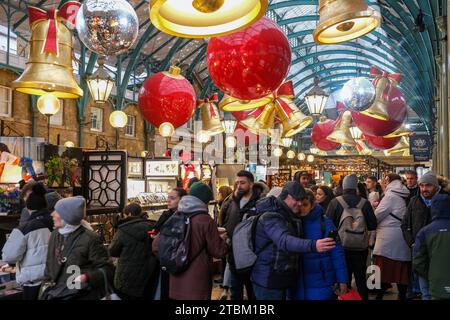 London, Großbritannien. Der Apfelmarkt von Covent Garden ist mit festlichen, übergroßen Glocken und Kugeln dekoriert Stockfoto