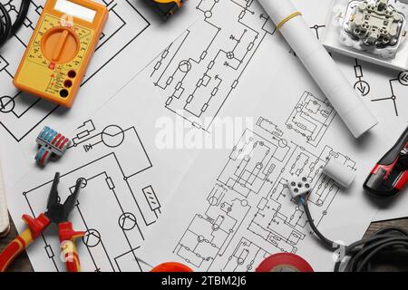 Schaltpläne, Digitalmultimeter und andere elektrische Geräte auf dem Tisch, flach gelegt Stockfoto