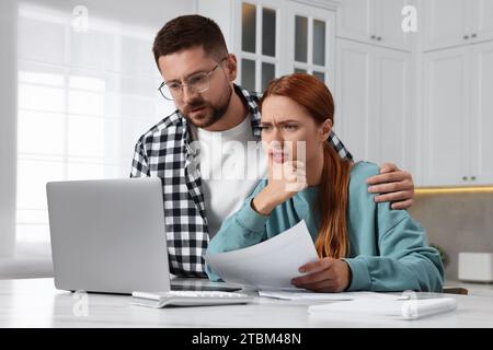 Paare, die einen Laptop für die Zahlung von Steuern zu Hause verwenden Stockfoto