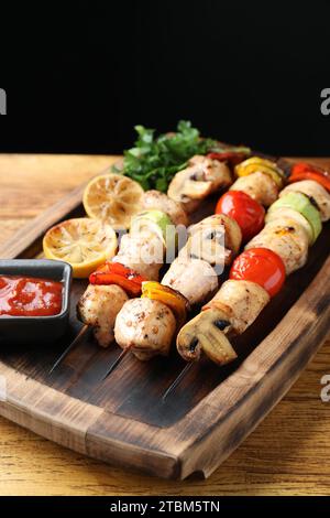 Köstliche Shish Kebabs mit gegrilltem Gemüse auf Holztisch Stockfoto