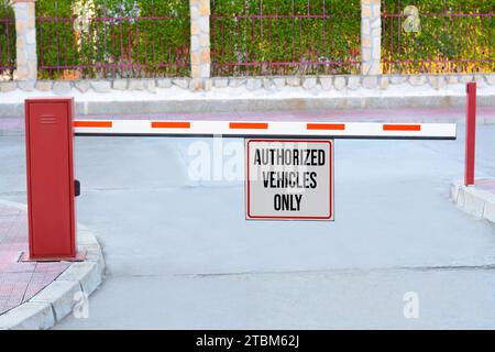 Schild mit Text autorisierte Fahrzeuge nur an Auslegerbarriere im Freien Stockfoto