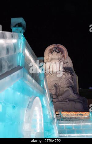 HARBIN, CHINA - 1. Januar 2022: Vertikale Abbildung der spektakulären beleuchteten weißen Eisskulpturen beim Harbin Ice and Snow Festival in Harbin, Hei Stockfoto