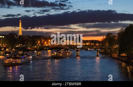 Schöne Nacht Paris, funkelnden Eiffelturm, Brücke Pont des Arts über den Fluss Seine und touristischen Boote. Frankreich Stockfoto