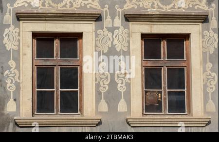 Alte Holzfenster im Vintage-Stil mit Verzierungen an der Wand. Außenansicht eines Gebäudes. Fenster im klassischen europäischen Stil in einem alten Gebäude Stockfoto