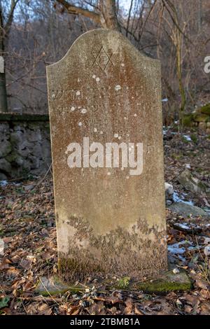 Alte alte alte verlassene jüdische Friedhof im Wald im Winter. Alte Grabsteine oder Grabsteine auf dem Friedhof Stockfoto