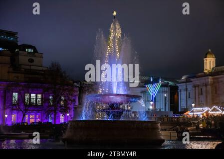 London, Großbritannien. Dezember 2023. Der Brunnen ist vom Weihnachtsbaum am Trafalgar Square in London zu sehen. Seit 1947 schenkt das norwegische Volk den Londoner Bürgern einen Weihnachtsbaum, um ihre Dankbarkeit für die Unterstützung Großbritanniens für Norwegen während des Zweiten Weltkriegs zu bekunden Quelle: SOPA Images Limited/Alamy Live News Stockfoto