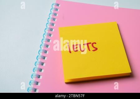Konzept von IELTS - International English Language Testing System Schreiben Sie auf Haftnotizen isoliert auf weißem Hintergrund. Stockfoto