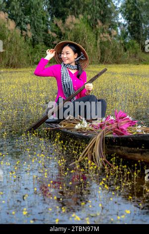 MOC Hoa District, Long an Province, Vietnam - 2. Dezember 2023: Frauen in Westvietnam während der Blütezeit Utricularia foliosa, ist eine große Sosa Stockfoto