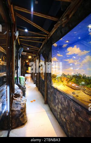 Blick auf einen Korridor mit verschiedenen Felsenexemplaren und Bergbau-Diorama-Szenen. Im Rock and Mineral Museum in Bangkok, Thailand. Stockfoto