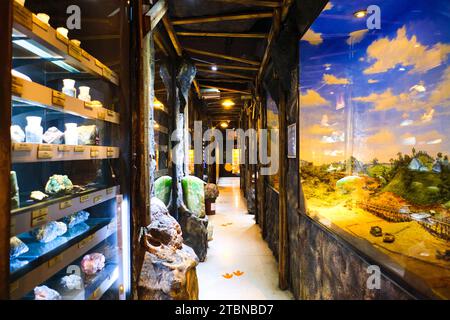 Blick auf einen Korridor mit verschiedenen Felsenexemplaren und Bergbau-Diorama-Szenen. Im Rock and Mineral Museum in Bangkok, Thailand. Stockfoto