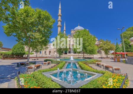 Aus der Ruhe eines Parks mit einem Brunnen des ägyptischen Basars erwacht die neue Moschee von Istanbul, deren elegante Minarette und kunstvolle Kuppeln erschaffen Stockfoto