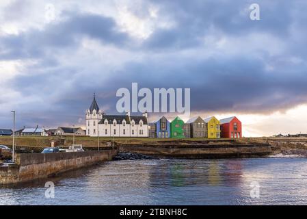 John O'Groats, Schottland, Großbritannien - 3. Dezember 2023: Blick auf das farbenfrohe The Inn John O'Groats Hotel mit sich nähernden Sturmwolken in Caithness County, SC Stockfoto