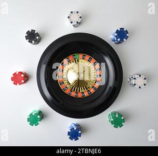 Casino Roulette Hintergrund isoliert auf weißem Tisch und Chips für Wetten herum. Draufsicht. Stockfoto