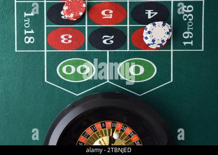 Detail des Roulette-Spieltisches mit Chips, die auf Zahlen und Roulette wetten. Draufsicht. Stockfoto