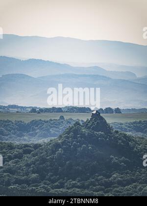 Burg von Salgo in Ungarn, Festung auf einem Berggipfel in einem Wald, nebeliger Morgen, Nebel, Dunst, Hügel im Hintergrund Stockfoto