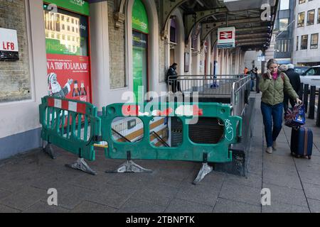 London, Großbritannien. Dezember 2023. Baubarrieren aus Kunststoff blockieren den Eingang zur U-Bahn vor der Charing Cross Station in London. Die zugfahrergewerkschaft ASLEF hat in ihrem langen und bitteren Streit mit 14 englischen Zugbetreibern über Lohn- und Arbeitsregelungen die jüngste Arbeitskampfrunde eingeleitet. Quelle: SOPA Images Limited/Alamy Live News Stockfoto