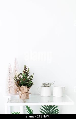 Leeres weißes Wohnzimmer mit minimalen kleinen Weihnachtsbäumen Stockfoto