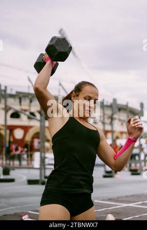 CrossFit-Wettbewerb für Damen. Frau mit Kurzhanteln. Stockfoto