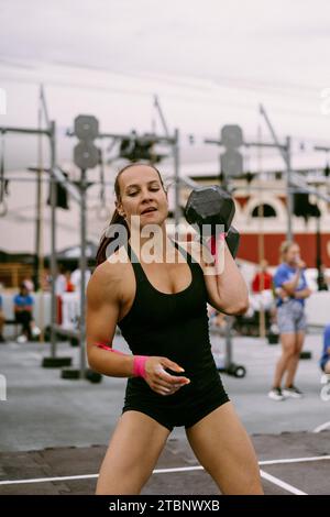 CrossFit-Wettbewerb für Damen. Frau mit Kurzhanteln. Stockfoto