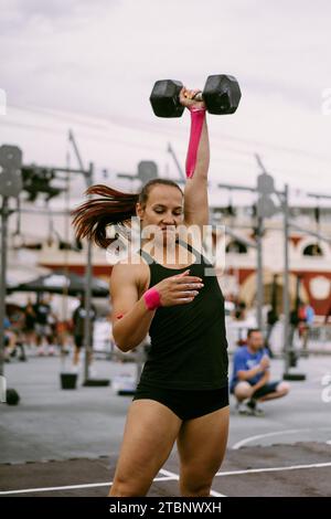 CrossFit-Wettbewerb für Damen. Frau mit Kurzhanteln. Stockfoto